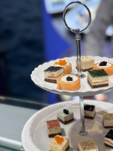 Etagere mit bunten Fischkonfekten und herzhaftem Fingerfood, garniert mit Kaviar.