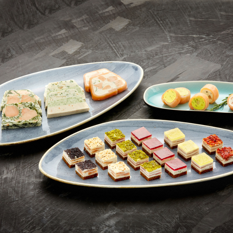 Räucherlachskonfekt Verschiedene bunte Fisch-Häppchen auf ovalen Tellern präsentiert.