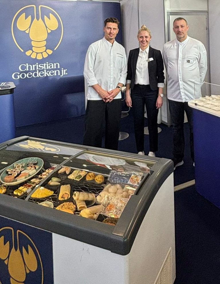 Claus Bruns, Ann-Jule Störte und Daniel Cerman vor dem Christian Goedeken Messestand in Salzburg