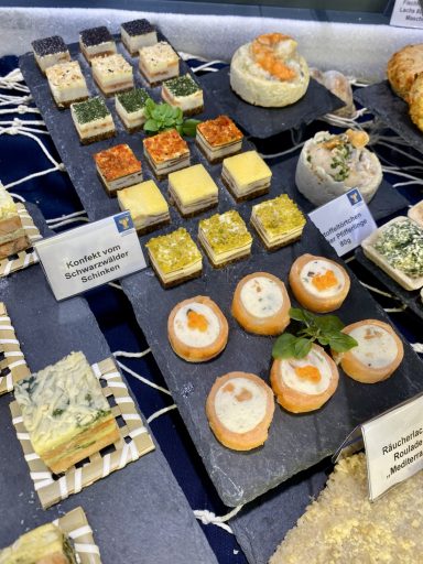 Eine Auswahl an verschiedenen Fisch-Häppchen auf einem schwarzen Servierbrett.