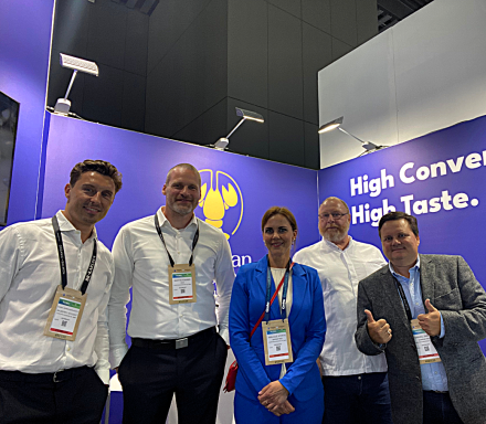 Fünf Personen stehen vor dem Messestand von Christian Goedeken mit blauem Hintergrund.