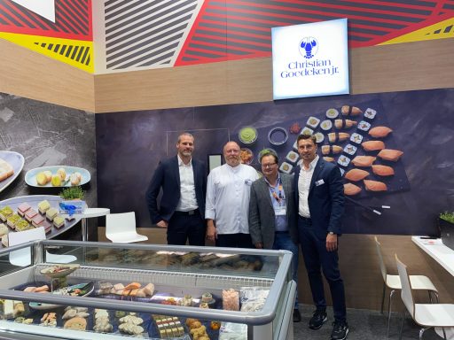 Vier Personen vor dem Messestand von Christian Goedeken auf der Anuga. Im Vordergrund eine Truhe mit Sushi und Meeresfrüchten.