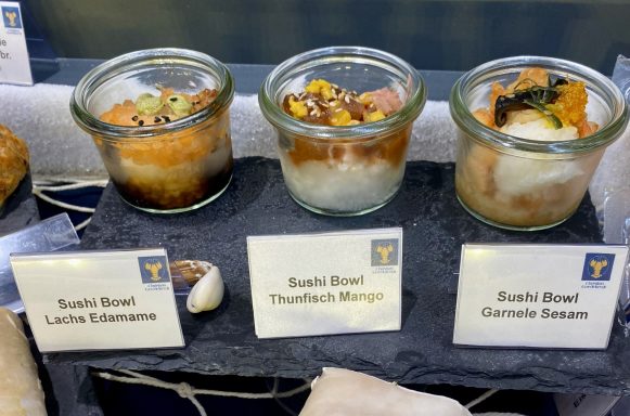 Drei Gläser mit Christian Goedeken Sushi-Bowls, jeweils mit verschiedenen Zutaten und Toppings.
