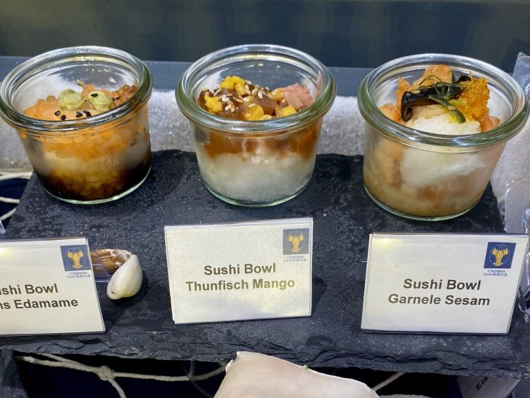 Drei Christian Goedeken Sushi-Bowls in Gläsern, jeweils mit verschiedenen Zutaten und Toppings.