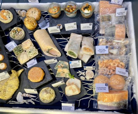 Verschiedene Meeresfrüchte und Fischgerichte präsentiert in der Kühltruhe auf einer Messe.