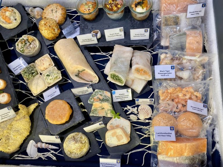 Produktpräsentation von verschiedenen Fisch- und Seafoodprodukten in einer Kühltruhe.
